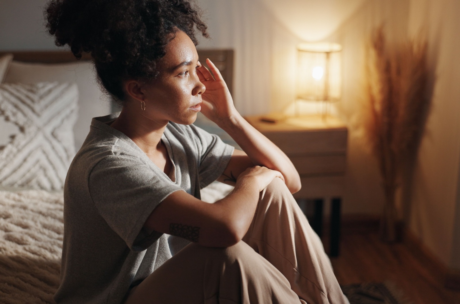 traurige frau sitzt auf bett