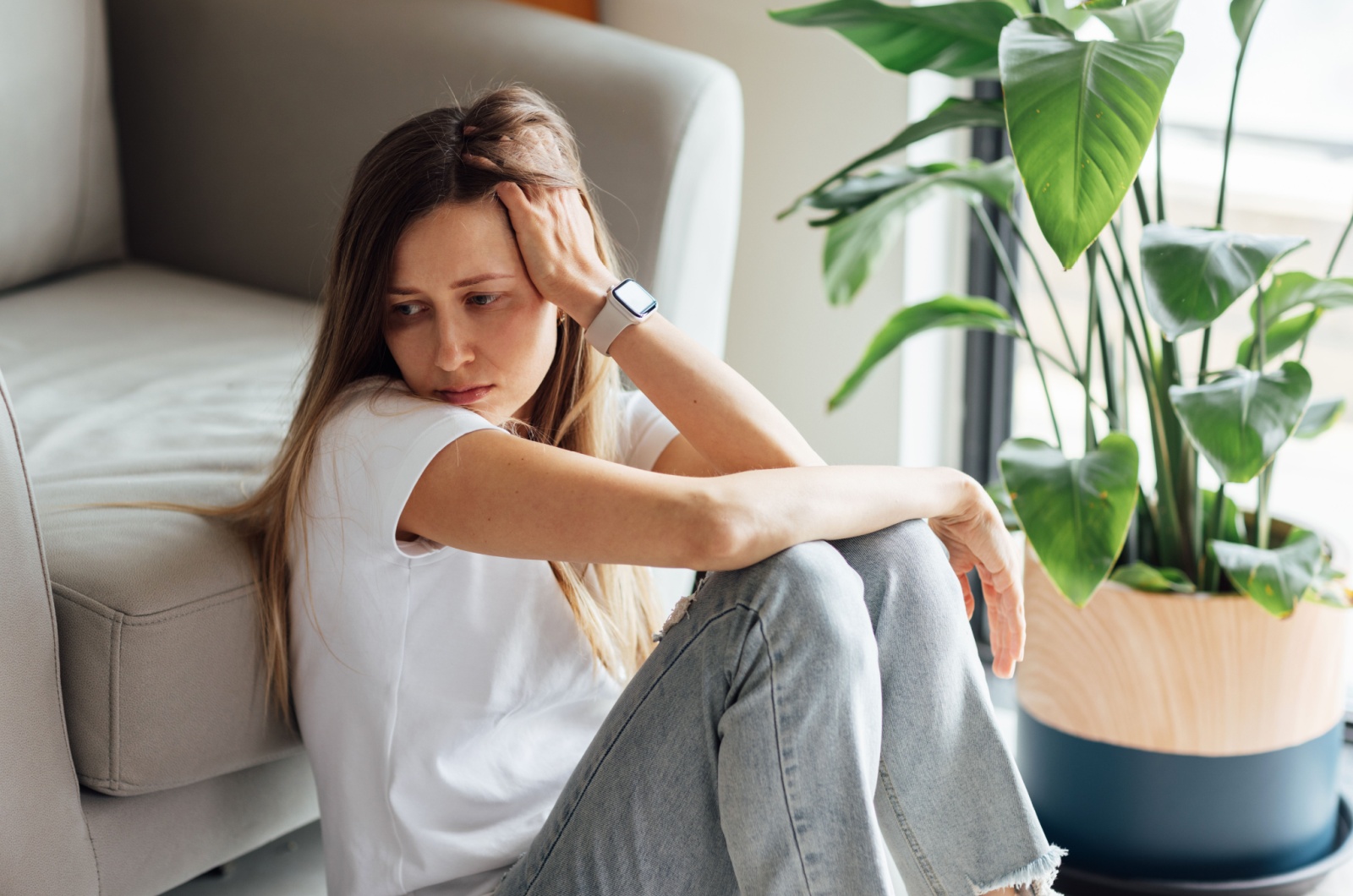 traurige frau sitzt vor sofa