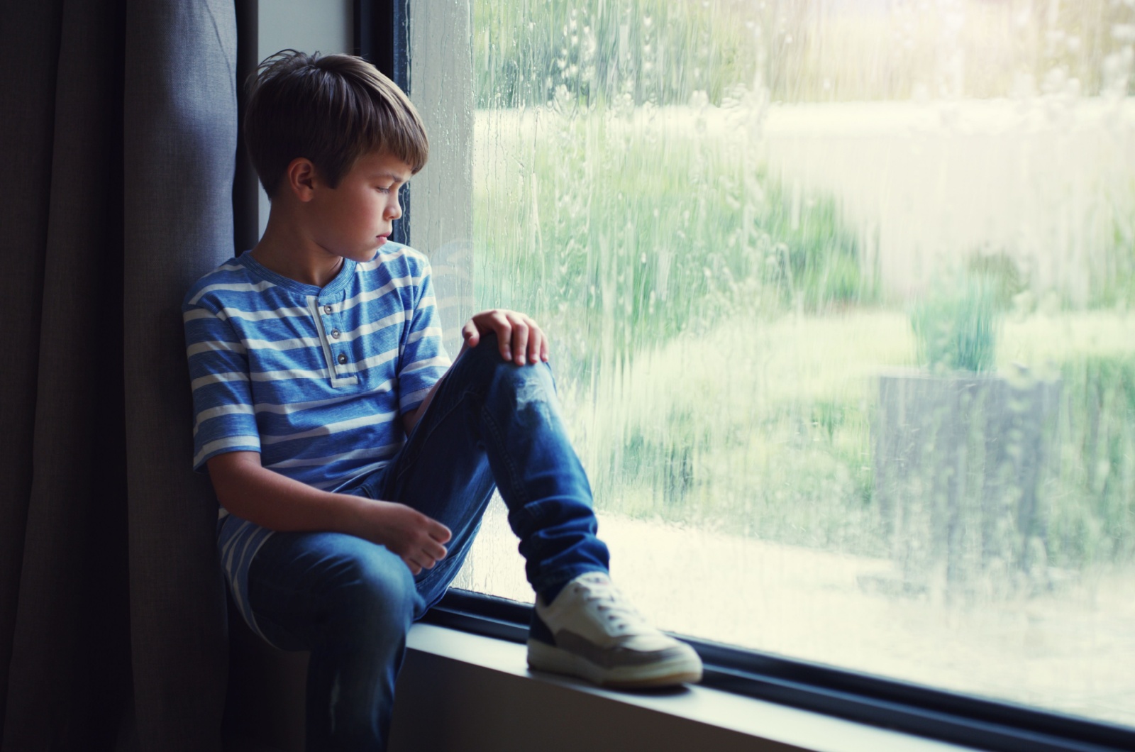 trauriger junge am fenster