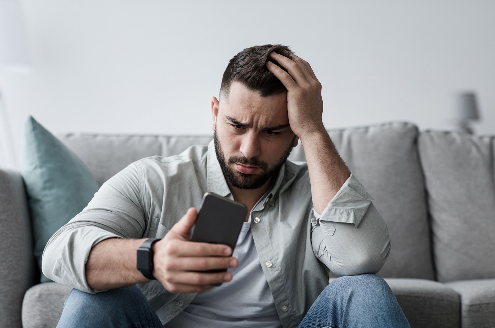 unsicherer mann sieht aufs handy