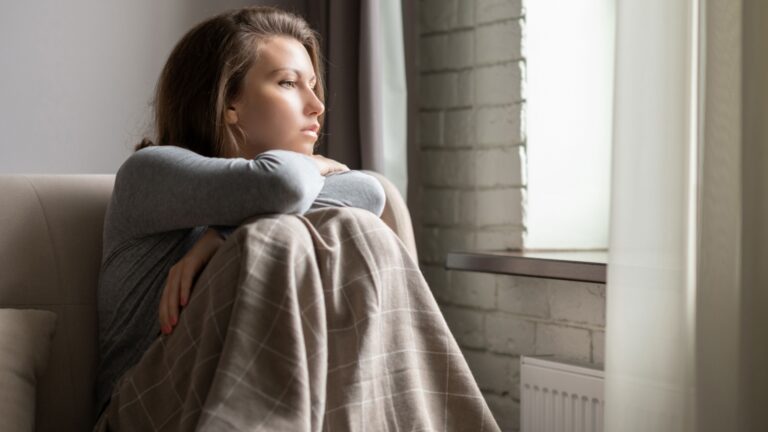 frau traurig sieht aus dem fenster