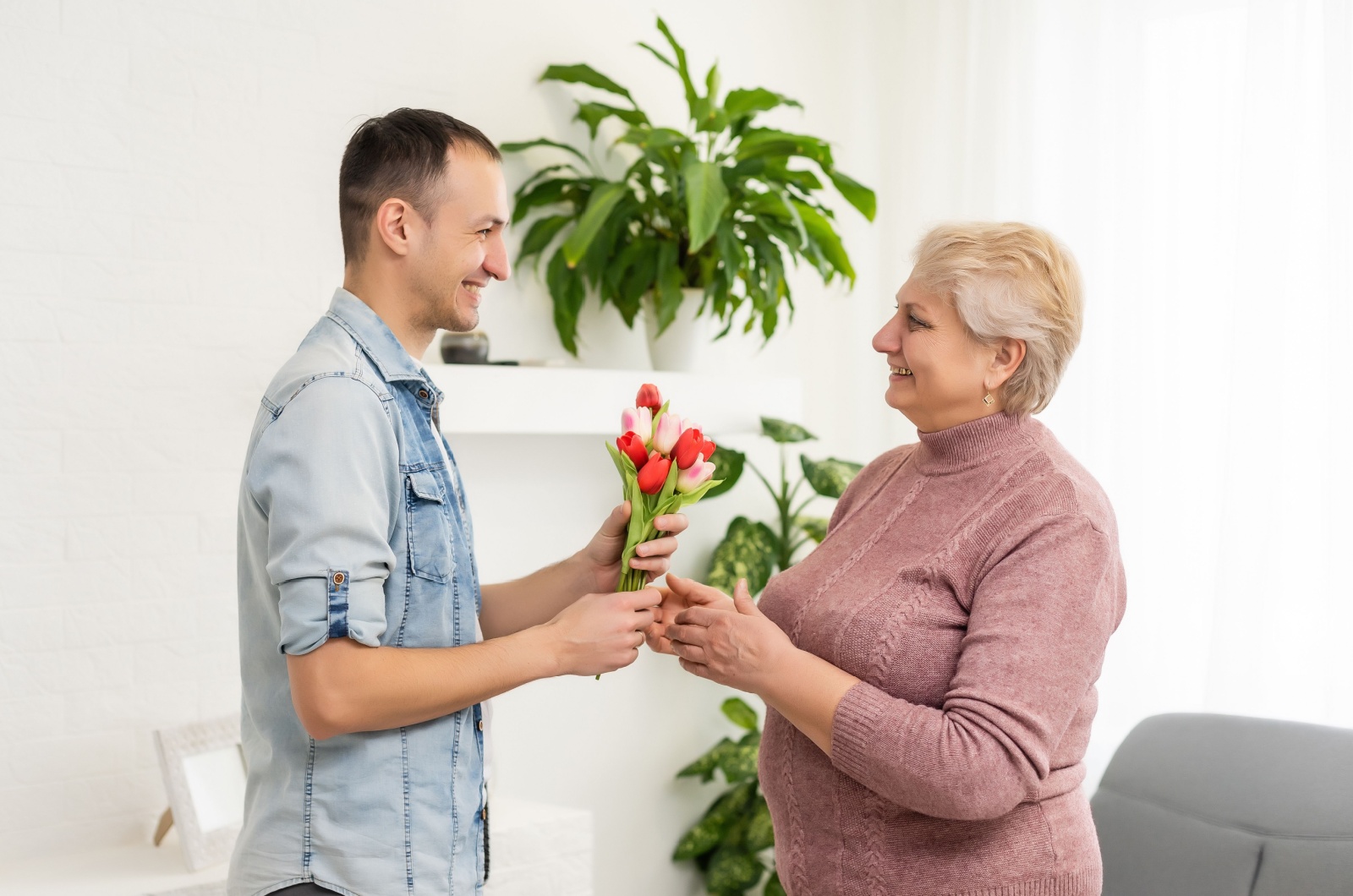 mann gibt mutter blumen