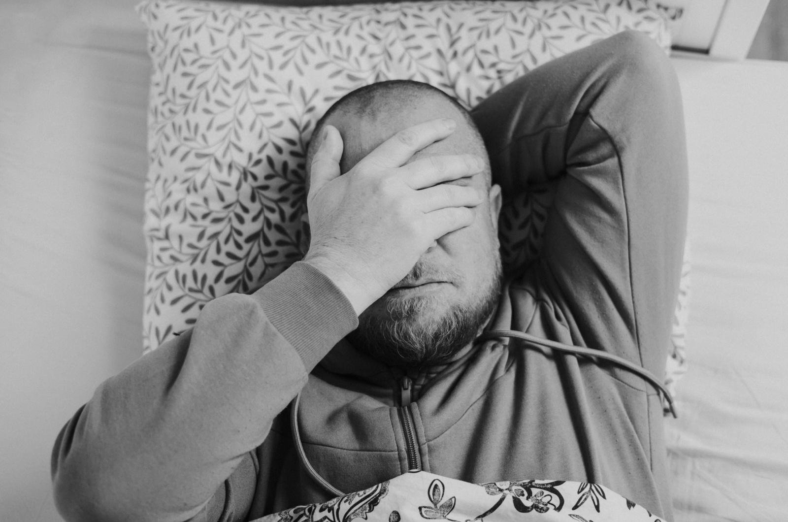 mann liegt traurig im bett