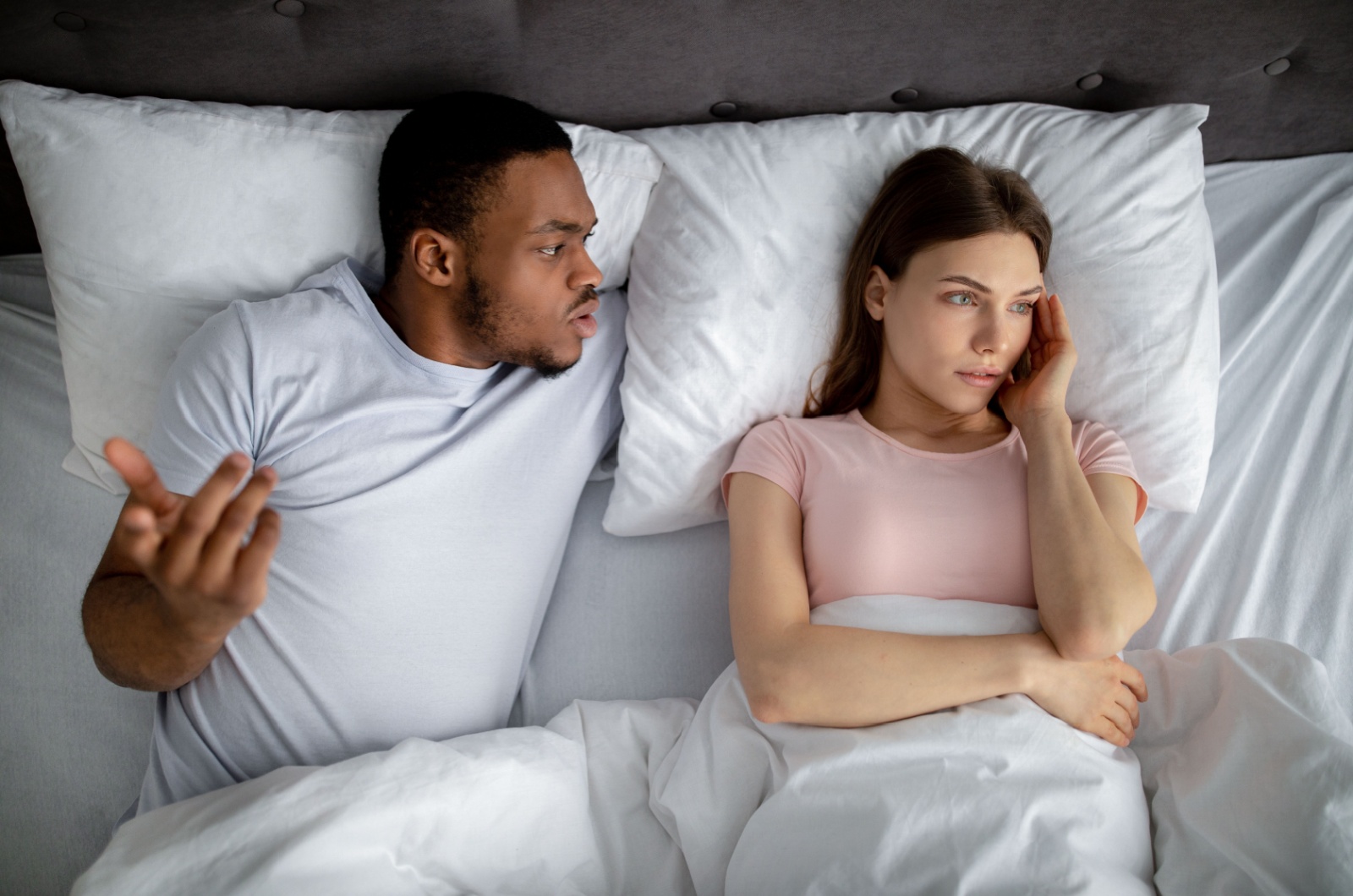 paar liegt im bett und streitet