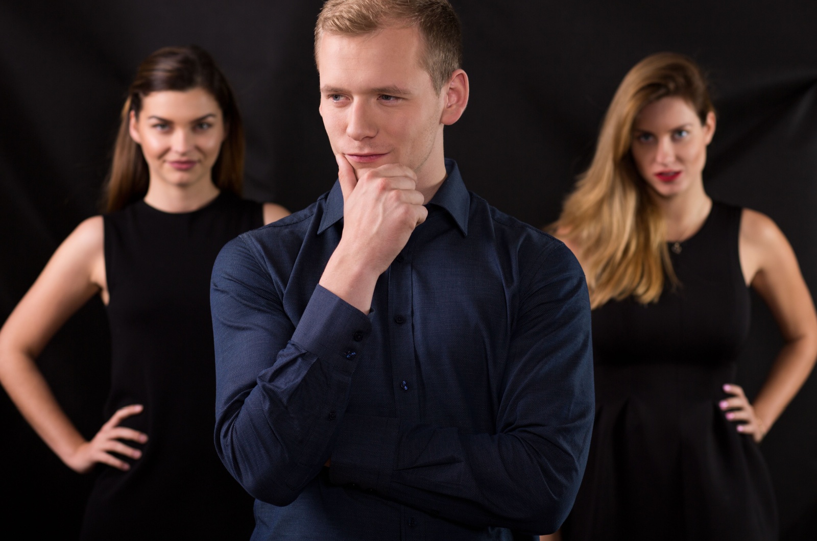 mann steht vor zwei frauen