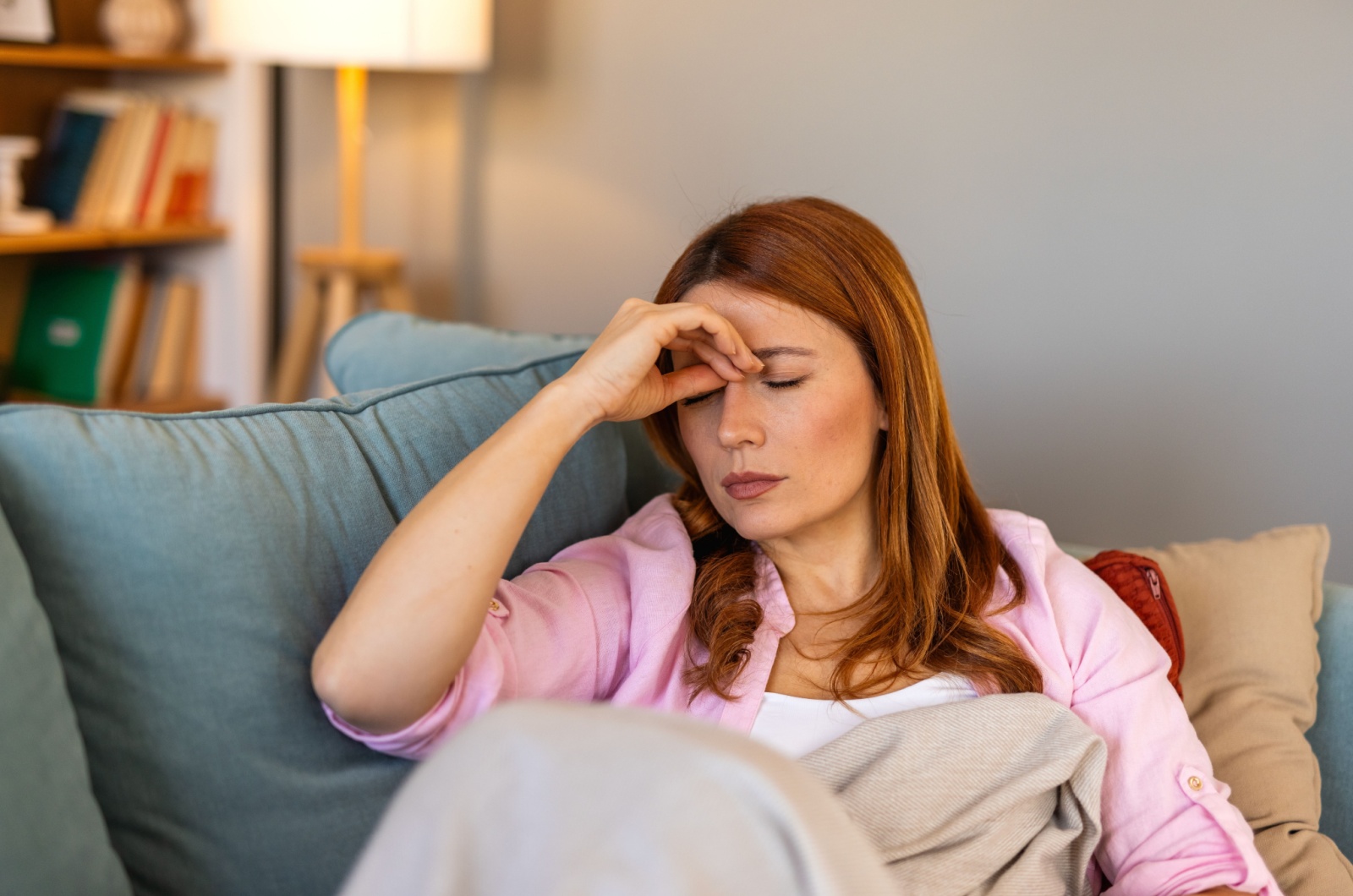 frau erschoepft liegt auf dem sofa