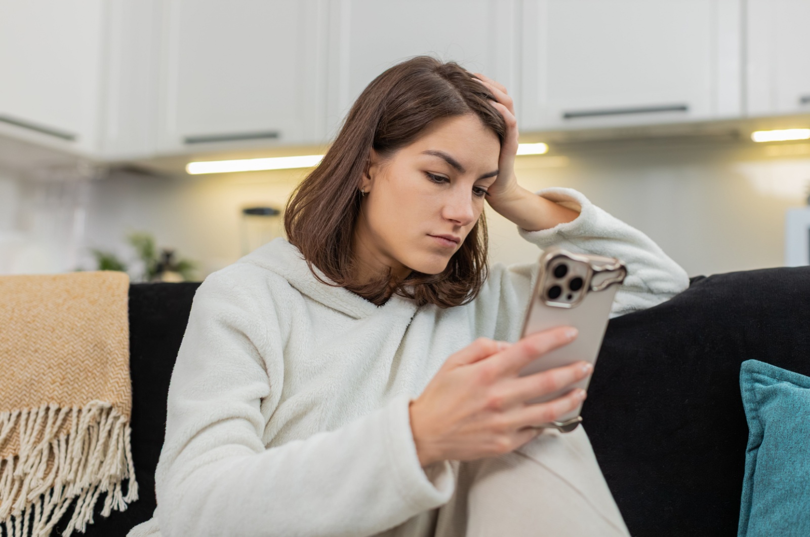 frau mit handy in ihrer hand traurig