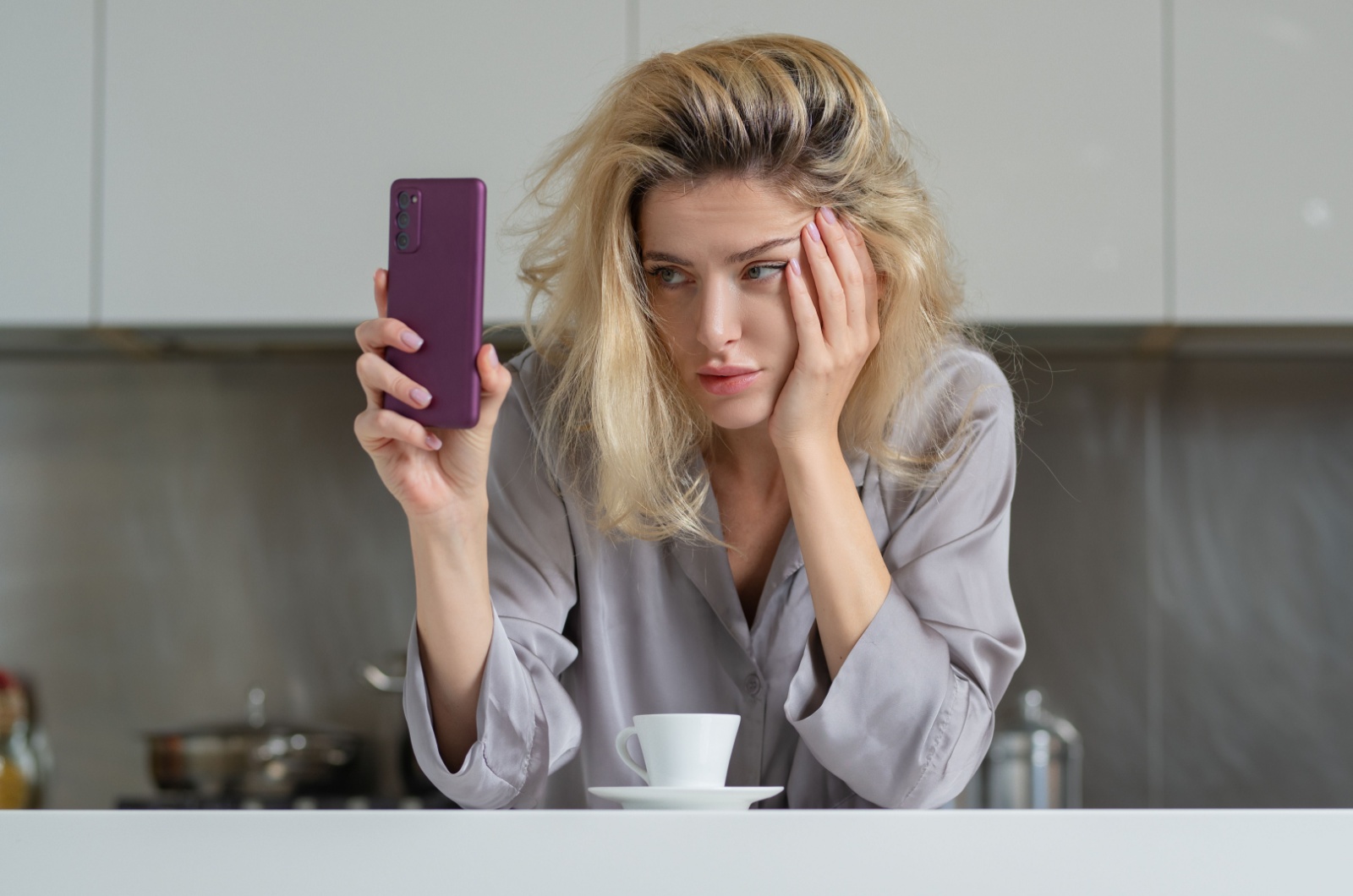 frau sieht genervt auf ihr handy