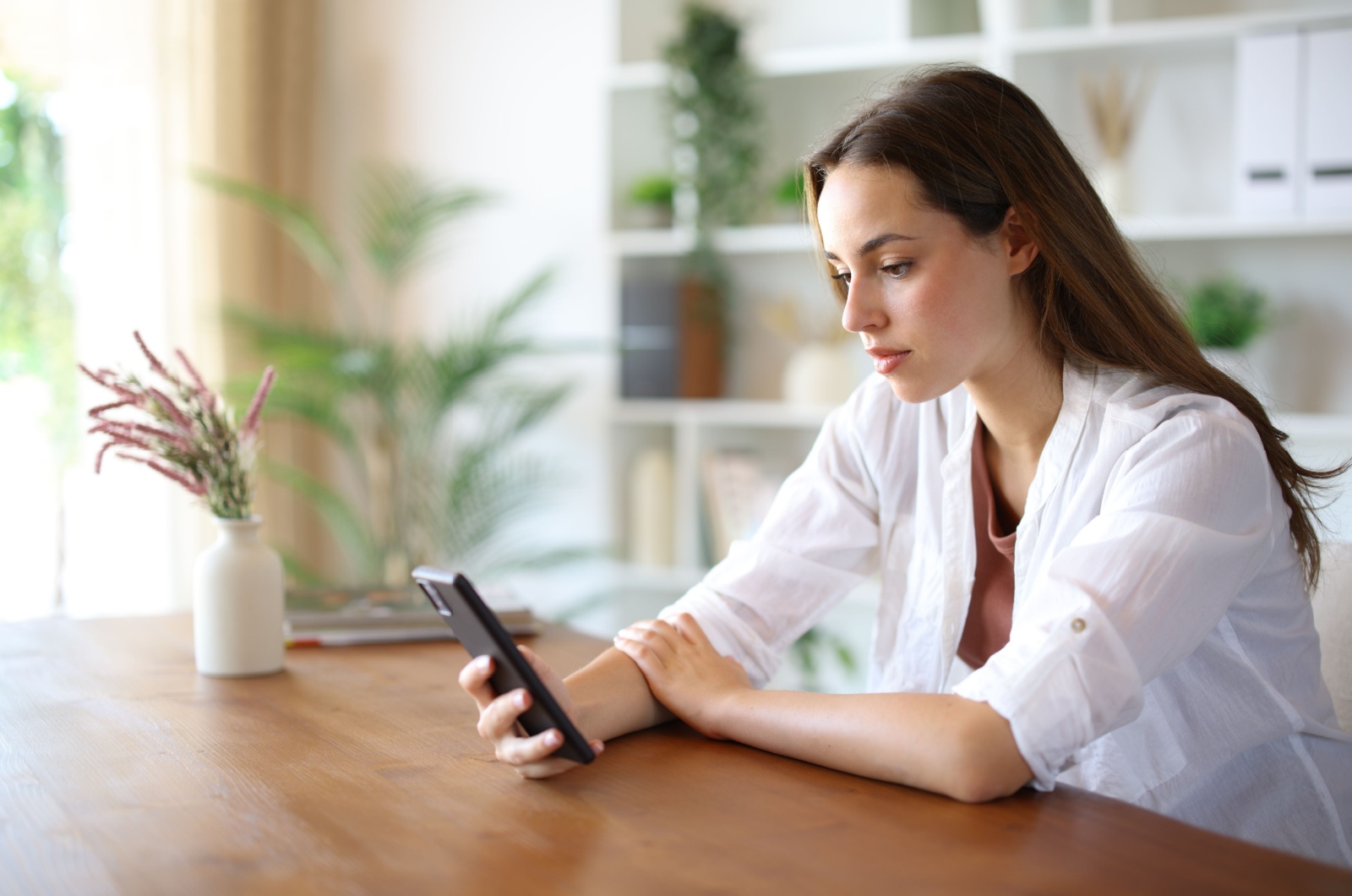 frau sitzt und sieht aufs handy