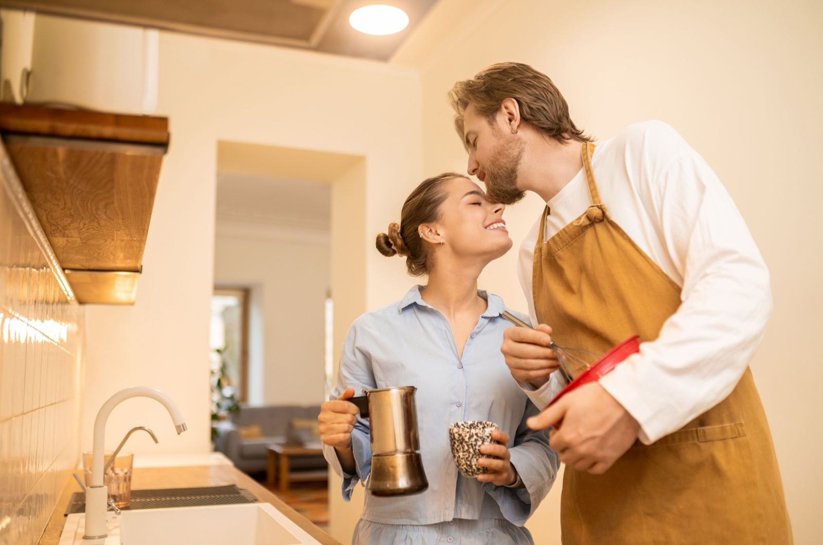 mann kuesst frau die kaffee macht