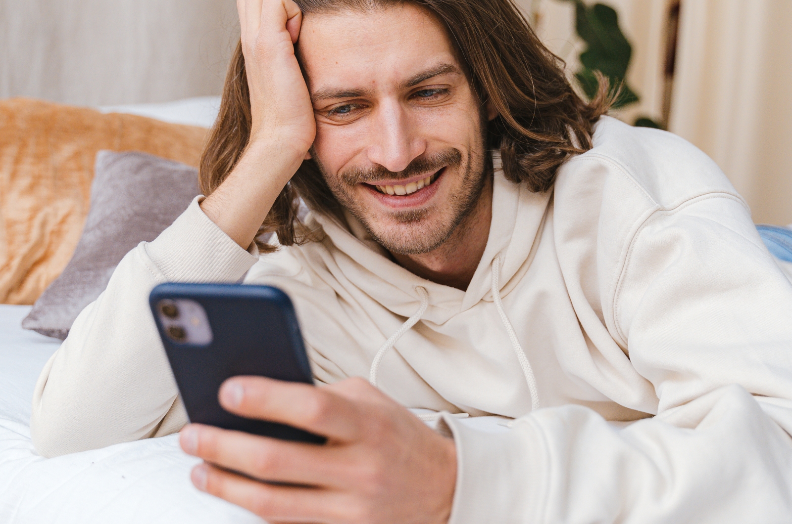 mann lacht und sieht aufs handy