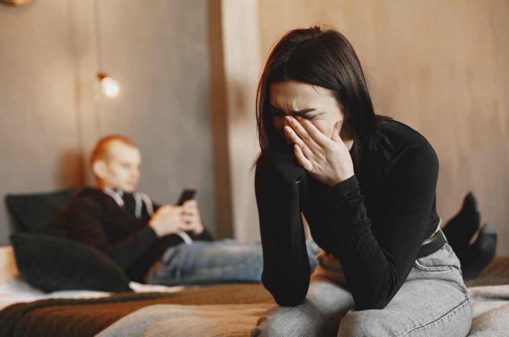 emotionale frau weint neben ignoranten mann